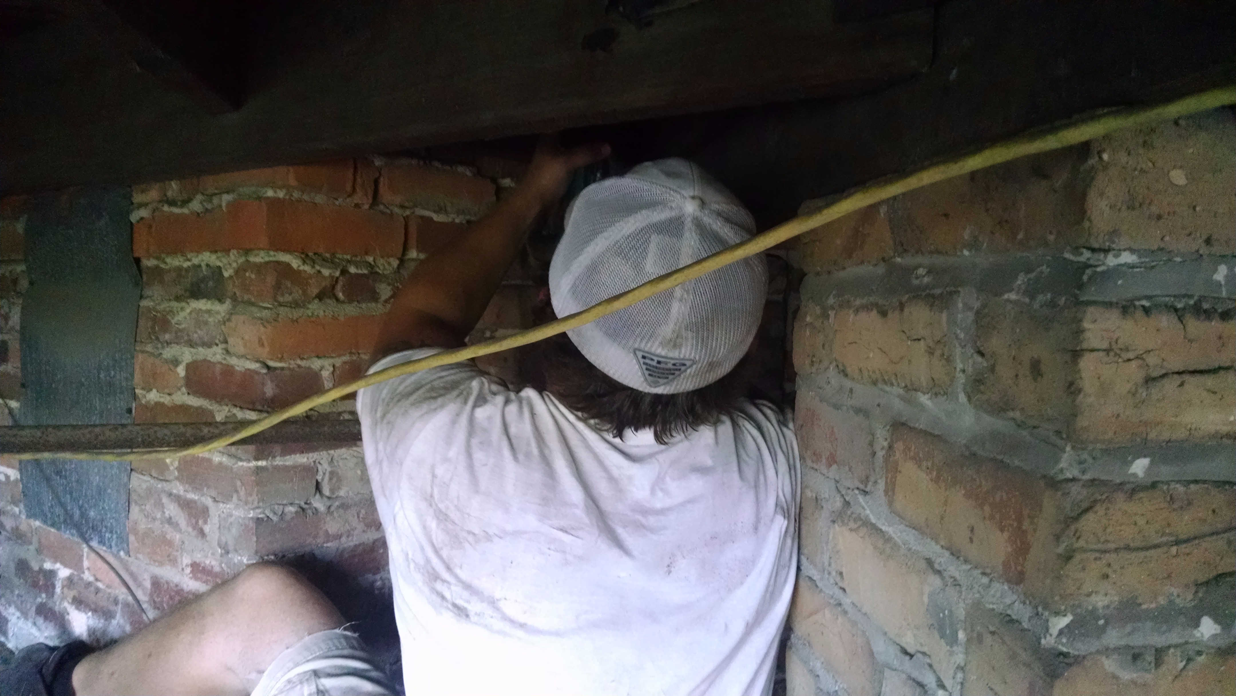 Jeffery Andrews working hard to figure out how to run freon lines. This is always a challenge in 100 year old homes