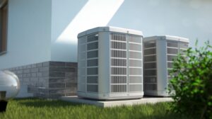 Two central AC units installed next to a house on a concrete pad surrounded by grass.
