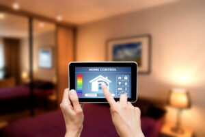 Person using a tablet to control a smart home HVAC heat pump system in a modern bedroom setting.